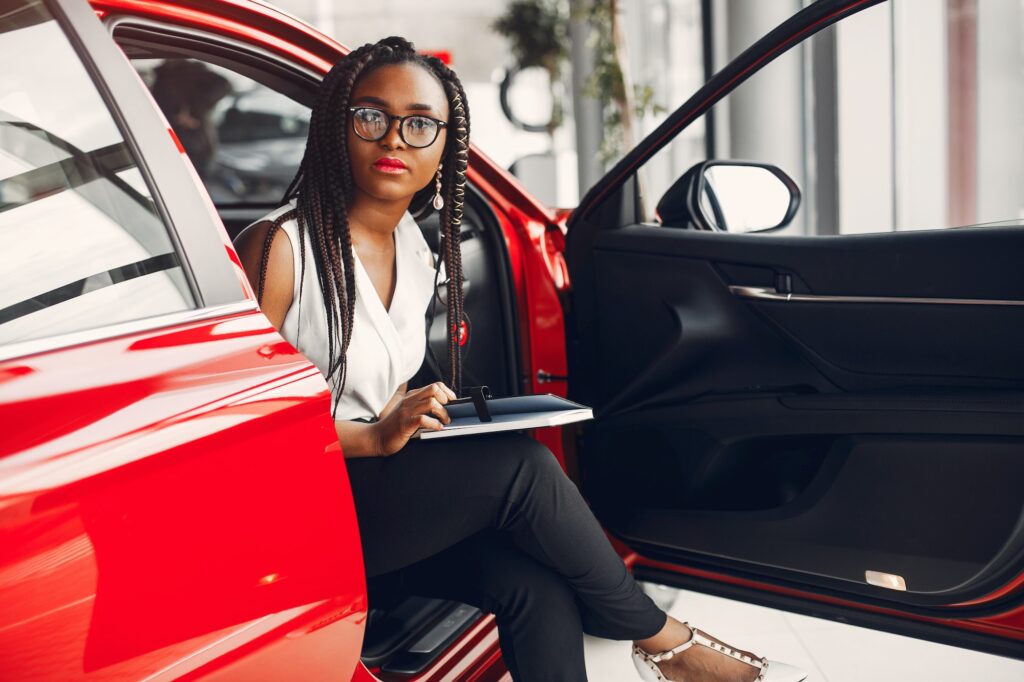 Stylish black woman in a car salon